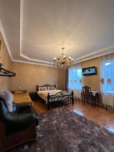 a bedroom with a bed and a chandelier at Guest House Elguja Qushashvili in Stepantsminda