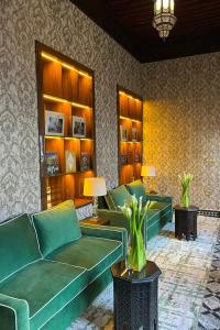un soggiorno con divani verdi e un tavolo con piante di Dar Tazi - Medina View a Fes