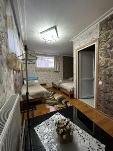 pokój z 2 łóżkami i stołem z kwiatami w obiekcie Guest House Elguja Qushashvili w mieście Stepancminda