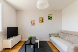 a living room with a couch and a flat screen tv at LET'S - 50 m² - T2 Part Dieu / centre - Wifi in Lyon
