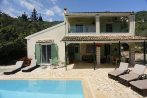 a house with a swimming pool in front of a house at Villa Rex - A little piece of heaven! in Nisakion