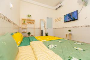 a bedroom with a bed with a green comforter at MTV Homestay Vũng Tàu in Vung Tau