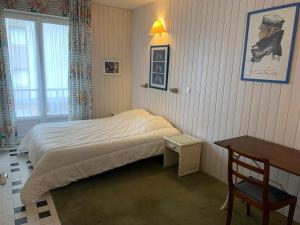 - une chambre avec un lit, une table et une chaise dans l'établissement Appt de 6 pers - Vu mer proche centre-ville, à Le Touquet-Paris-Plage