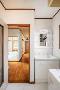 a white bathroom with a sink and a mirror at 世界遺産と東武日光駅に近い 全内装 3階まで階段あり 駐車場 子供不可 in Nikko