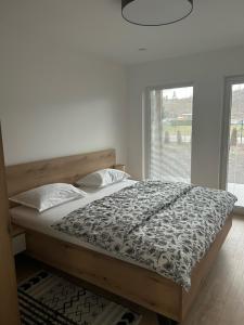 a bed in a bedroom with a large window at Chalets New Apartmány Ivachnová in Ivachnová