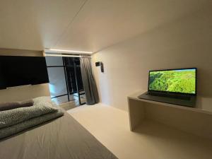 Habitación con cama y TV en la pared. en Sleep&Go Hostel Ljubljana, en Liubliana