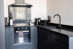a kitchen with a black counter top and a sink at Withnell Stays - Apartment Four - Ground Floor in Blackpool