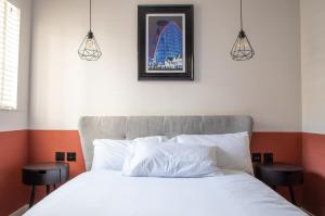 une chambre avec un lit blanc avec deux tabourets dans l'établissement Withnell Stays - Apartment Four - Ground Floor, à Blackpool