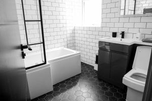 a bathroom with a tub and a toilet and a sink at Withnell Stays - Apartment Four - Ground Floor in Blackpool