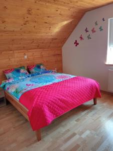 - une chambre avec un grand lit et une couverture rose dans l'établissement Ranč Stojnšek, à Rogaška Slatina