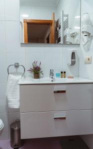 a white bathroom with a sink and a mirror at A Casa Antiga do Monte Apartamentos Turísticos - Pontecesures in Padrón