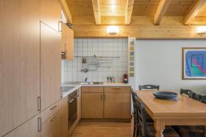 une cuisine avec des placards en bois et une table en bois dans l'établissement Ambiente B21, à Bettmeralp