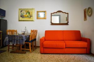 sala de estar con sofá naranja y mesa en Bed & Breakfast Mare Nostrum, en Brindisi
