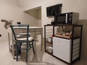 a room with a desk with a microwave and a chair at Casa Roberta in Dolceacqua