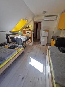 Zimmer mit 2 Betten, einem Tisch und einer Küche in der Unterkunft Apartma LINA, Encijan D-38 in Bohinj