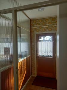 korytarz z drewnianymi drzwiami i oknem w obiekcie B&B Ut Kantuurke w mieście Neer