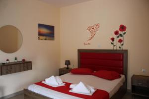 a bedroom with a large bed with red pillows at House Stamatis in Sarti