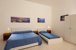 ナポリにあるGeco's Apartmentのベッドルーム1室(ベッド2台付)が備わります。壁には絵画が飾られています。