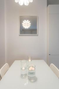 a white table with two candles and two glasses at White Candle Apt, Close to San Pietro, Gemelli and City Center in Rome