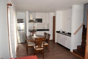 a kitchen with a table and chairs and a refrigerator at Condominio Los Miradores in Papudo