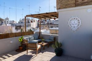 un patio avec des chaises et un canapé sur le toit dans l'établissement Suite Torre Arcobasso, à Bari