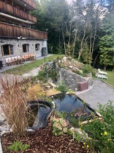 a garden with a pond in front of a building at Colorado Riders Chalet in Crans-Montana