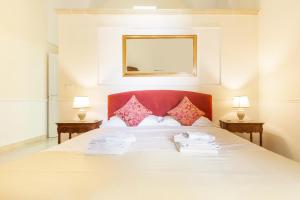 a bedroom with a large white bed with two lamps at Dimora Le Tre Muse Guesthouse in Lecce