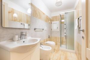 ein weißes Bad mit einem Waschbecken und einem WC in der Unterkunft Dimora Le Tre Muse Guesthouse in Lecce