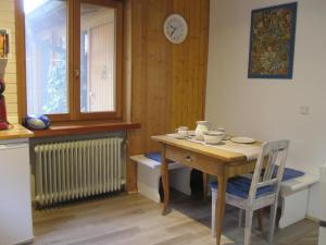 a kitchen with a table and a clock on the wall at Ferienwohnungen Blätterrausch in Schwandorf in Bayern