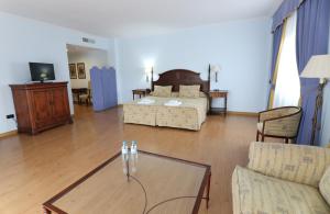 - un salon avec un lit et une table basse dans l'établissement Hospedium Hotel Doña Mafalda de Castilla, à Plasence