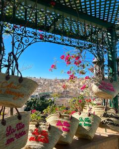a group of baskets filled with flowers on a balcony at Dar Tazi - Medina View in Fès