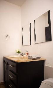 a bathroom with a sink and two mirrors on the wall at Casa de campo en Cienaga de Oro 