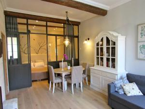 Una sala de estar con una mesa y un comedor. en Typical 18th century flat, historical center, en Aviñón