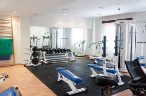 une salle de sport avec plusieurs tapis de course et machines dans l'établissement ARVA Santiago León, à León