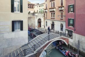 ヴェネツィアにあるカ デル カンポの運河橋上に立つ男
