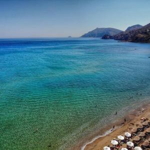 plaży z grupą parasoli i oceanu w obiekcie Goldfish Seaside Luxury Houses w mieście Kómi