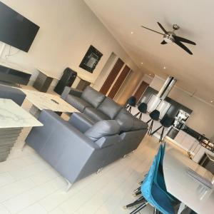 een woonkamer met een bank en een tafel bij Luxury large 4 bedrooms Beach front house in Sere Kunda