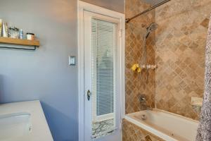 a bathroom with a tub and a shower with a window at WFH-Friendly Washington DC Vacation Rental! in Washington, D.C.