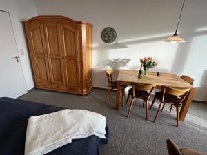 uma sala de jantar com mesa e cadeiras e um armário em Haubentaucher em Fehmarn