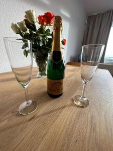 uma garrafa de champanhe e dois copos numa mesa em Haubentaucher em Fehmarn