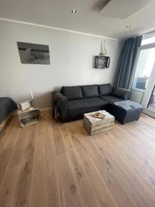 un soggiorno con divano e pavimento in legno di MeerRuhe a Burgtiefe auf Fehmarn 