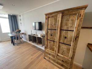 a large wooden cabinet in a room with a table at MeerRuhe in Burgtiefe auf Fehmarn 