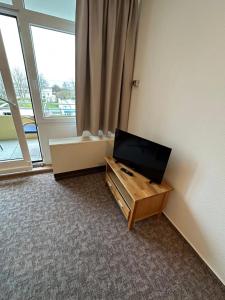 a room with a flat screen tv in a room with a window at Seepferdchen in Burgtiefe auf Fehmarn 
