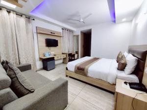 ein Hotelzimmer mit einem Bett und einem Sofa in der Unterkunft BlueNeck Sec 47 Near IKEA GMP Gurugram in Gurgaon