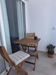 una mesa de madera y una silla en el balcón en Sirena Iris en El Cotillo