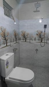 uma casa de banho com WC e uma pintura de árvores em Shan Villa em Bentota