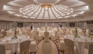 a banquet hall with white tables and chairs and two men at Clayton Hotel Düsseldorf City Centre in Düsseldorf +71 photos