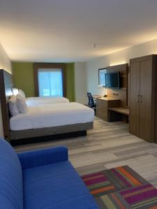 a bedroom with a bed and a tv and a couch at Holiday Inn Express & Suites San Antonio West Sea World Area by IHG in San Antonio
