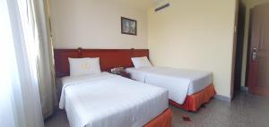 two beds in a hotel room with at LUCASTA SAIGON Hotel in Ho Chi Minh City