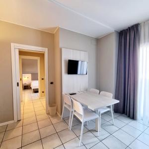 una sala da pranzo con tavolo e sedie bianchi di Le Terrazze sul Lago Hotel & Residence a Padenghe sul Garda